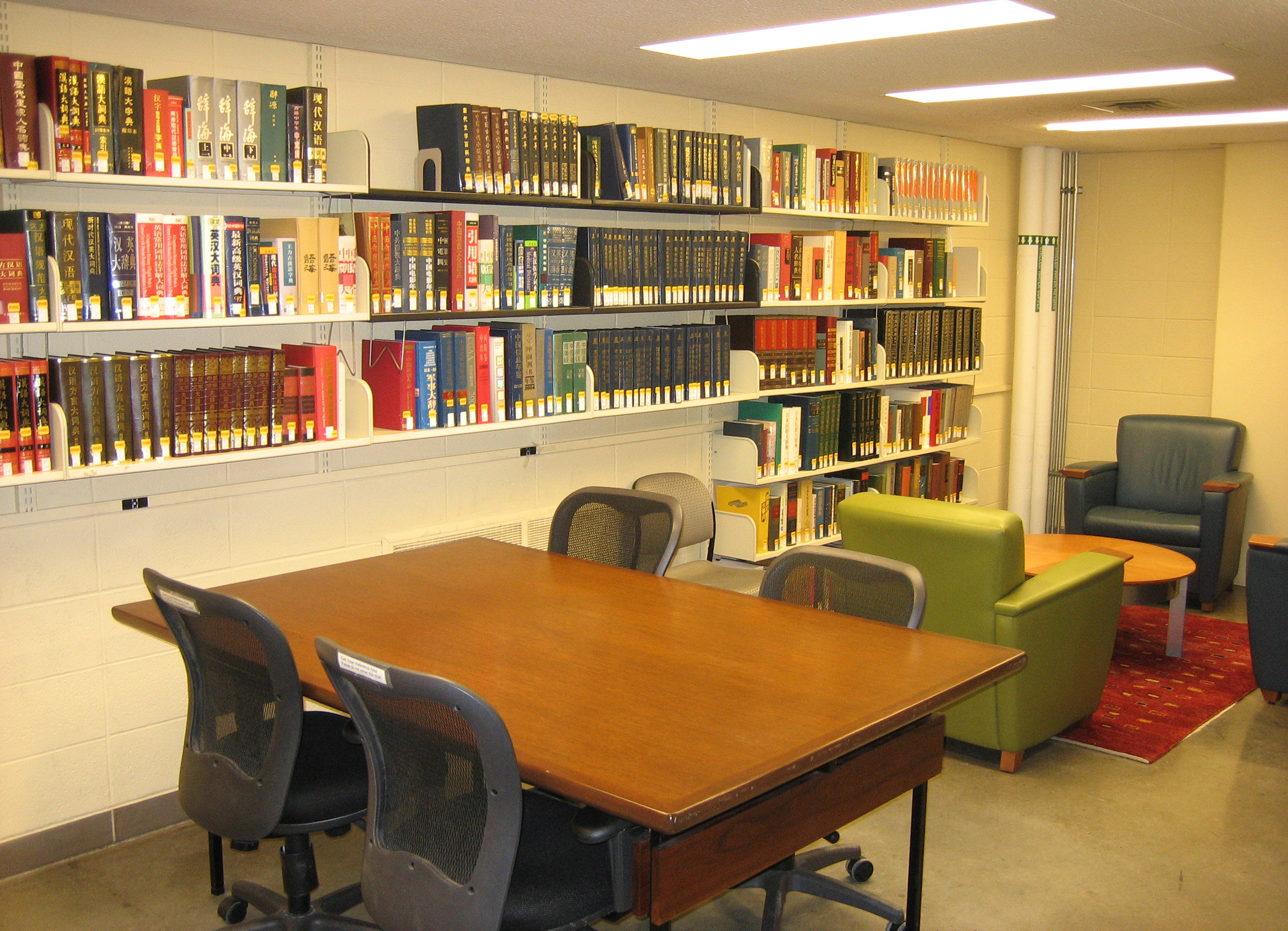 bookshelves, chairs, and worktables with fluorescent lighting